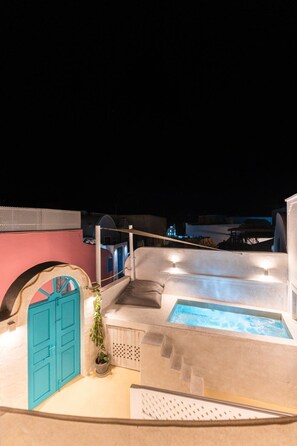 A rooftop pool area with a hot tub, a blue door, and a staircase leading to a terrace. - Marla Luxury Residences (Santorini)