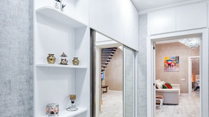 A modern interior with white walls, a curved white shelving unit, and a wooden floor. - H&B apartments Agmashenebeli II (Tbilisi)