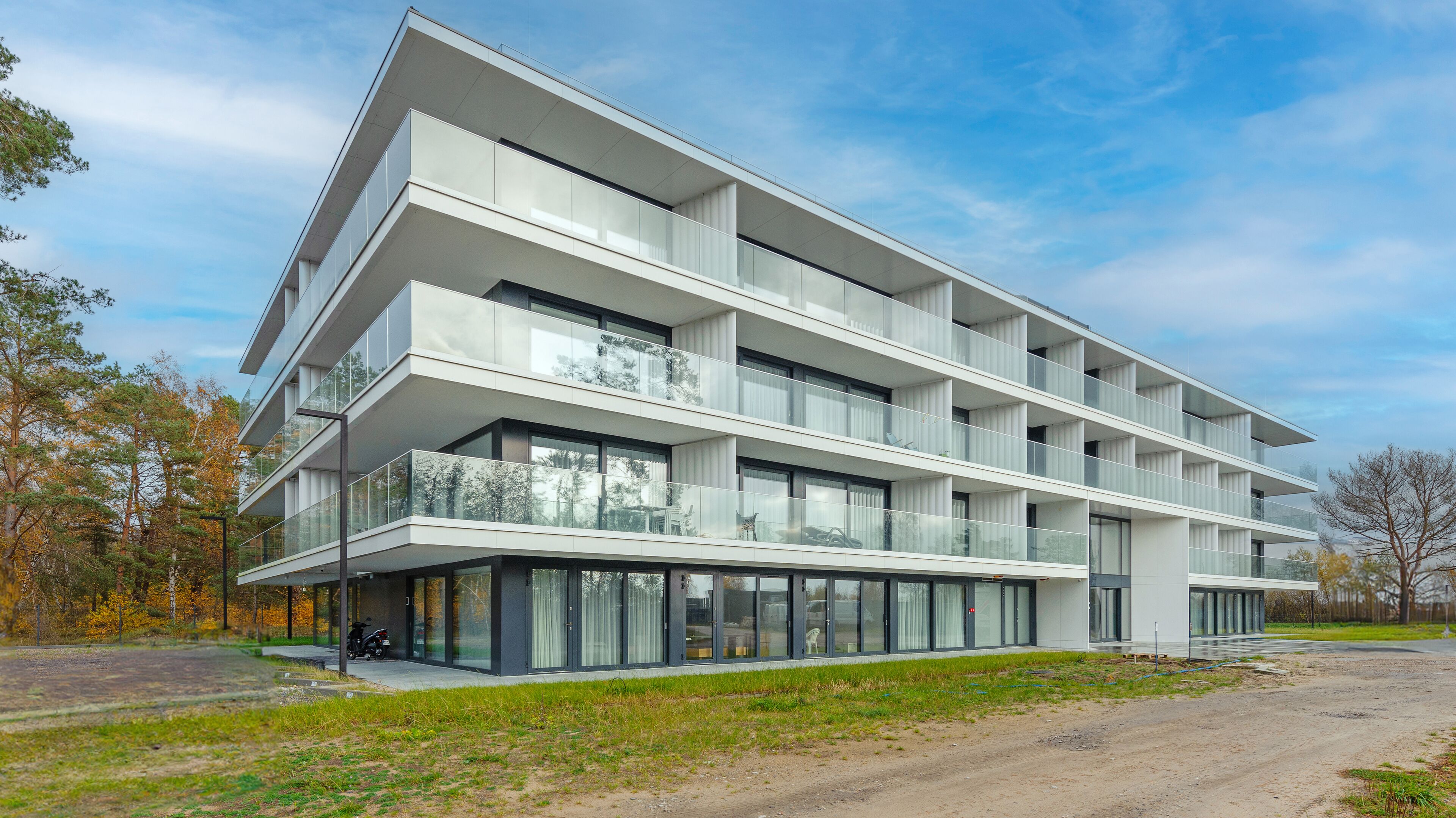 Un edifici modern d'edifici amb grans finestres de vidre i balcons.