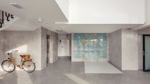 A modern interior with a marble wall, a bicycle, and a minimalist design.