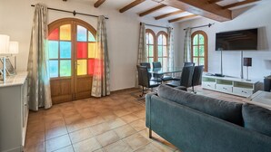 Un grand salon avec une grande fenêtre, une table à manger avec des chaises et un canapé.