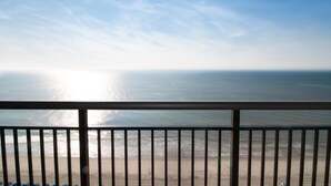 A beach view from a balcony with a railing. - Ocean's Edge Bliss with Dual Balconies (Myrtle Beach)