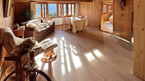 A spacious wooden cabin with a large living area, a dining table, and a cozy seating arrangement. - Wohnung Lake View (Schwanden bei Brienz)