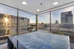 A modern room with a large window, a marble-topped table, and a view of a cityscape.