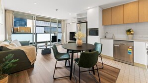 Un apartamento moderno con comedor, cocina y un amplio ventanal que ofrece vistas a la ciudad.