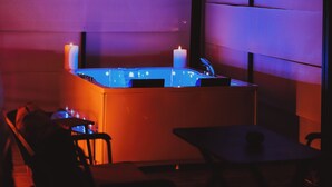 Una stanza scarsamente illuminata con un'area bar, un tavolo e delle sedie.