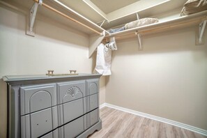 A bedroom with a dresser, a bed, and a closet with hanging clothes. - Mesquite 2BR Townhome with Pool & Gym Access (Mesquite)
