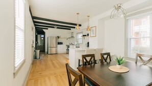 A modern kitchen with white cabinets, a central island, and pendant lighting. - Quaint, Vintage Reno in Manheim (Manheim)