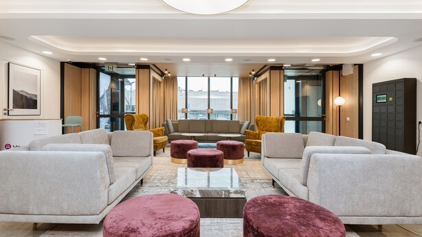 Un lobby moderno con un conjunto de sofá, dos sillones y una mesita de centro.
