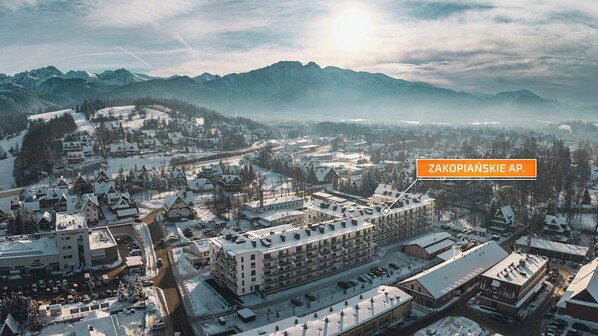 Uma cidade coberta de neve com um edifício imponente identificado como "Zakopjanske AP".