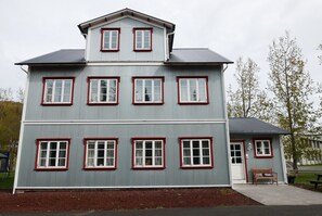 A two-story building with multiple windows and a small porch area.