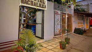 A building with a sign reading "Hostal Machalilla" and a map on the wall.
