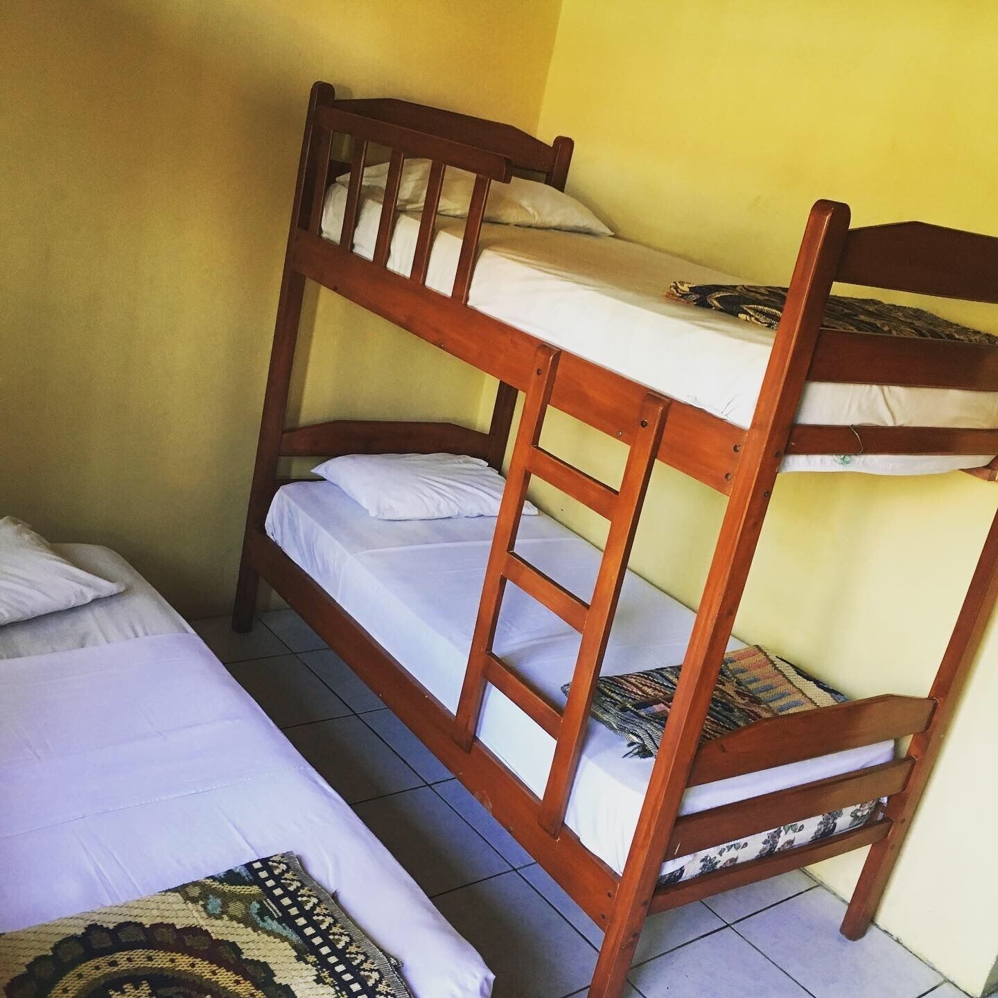 A bunk bed with two levels, each with a mattress and pillows.