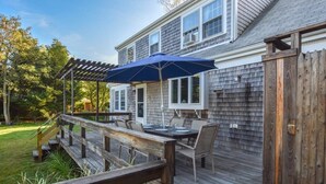 A deck with outdoor furniture and a pergola. - Sleeps 8, Minutes to Nauset Beach! (Orleans)