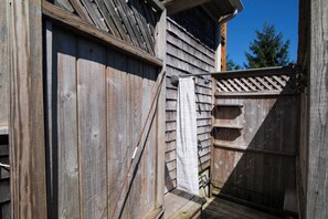Eine Holzhütte mit geneigtem Dach und einer kleinen Veranda.