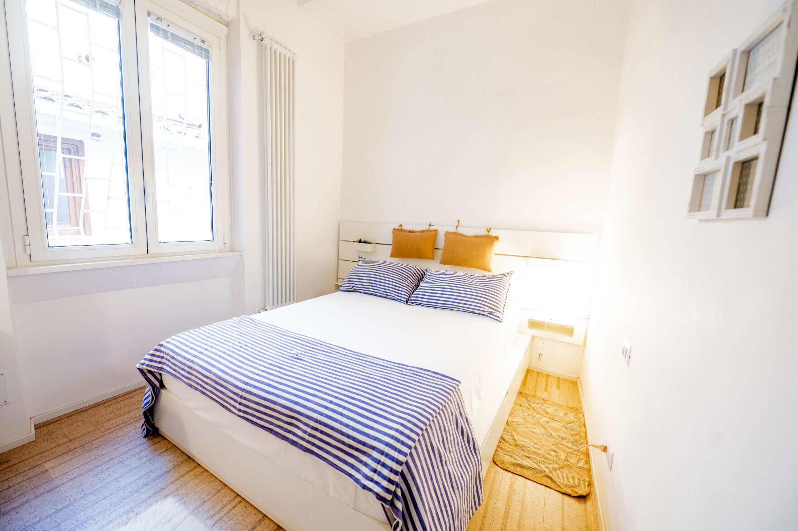 Une chambre à coucher avec un lit, une fenêtre et un plancher en bois.