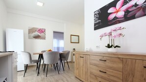 Una cocina moderna con comedor, armarios de madera y una pequeña mesa con sillas.