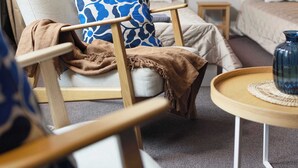 A modern living room with a sofa, armchair, and a small round table with a vase. There are framed artworks on the wall and a bed in the background. - Huge apartment with Sauna and free parking (Duisburg)