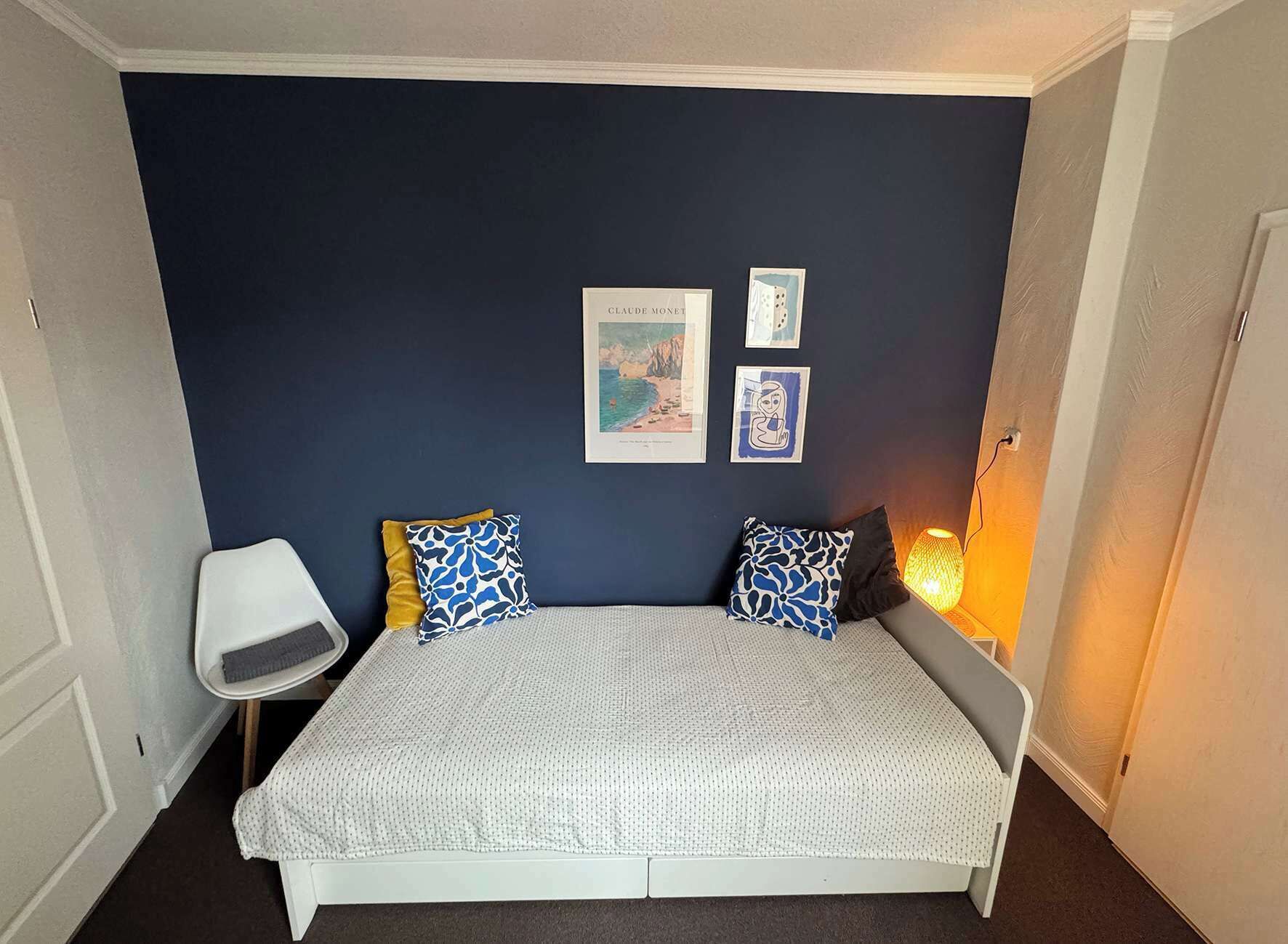 Une chambre à coucher avec un lit, une chaise et une table de chevet.