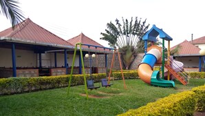 Ein Spielplatz mit Schaukeln, Rutschen und einer Kletterkonstruktion.
