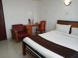 Una habitación de hotel con una cama, un escritorio y dos sillas.