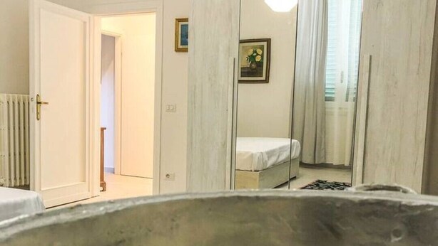 A room with a bed, a large mirror, and a bowl of decorative items. - 1 bedroom apartment in florence (Firenze)