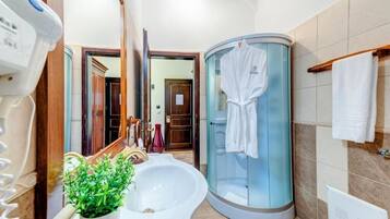 A modern bathroom with a large mirror, a sink, a glass shower enclosure, and a towel rack.