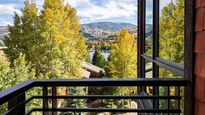 Ein Balkon mit Blick auf einen See, Bäume und Berge.