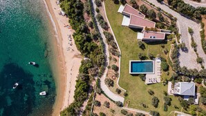 An aerial view of a coastal property with a swimming pool, multiple houses, and a beach. - Villa Pelagoon  (Skiathos)