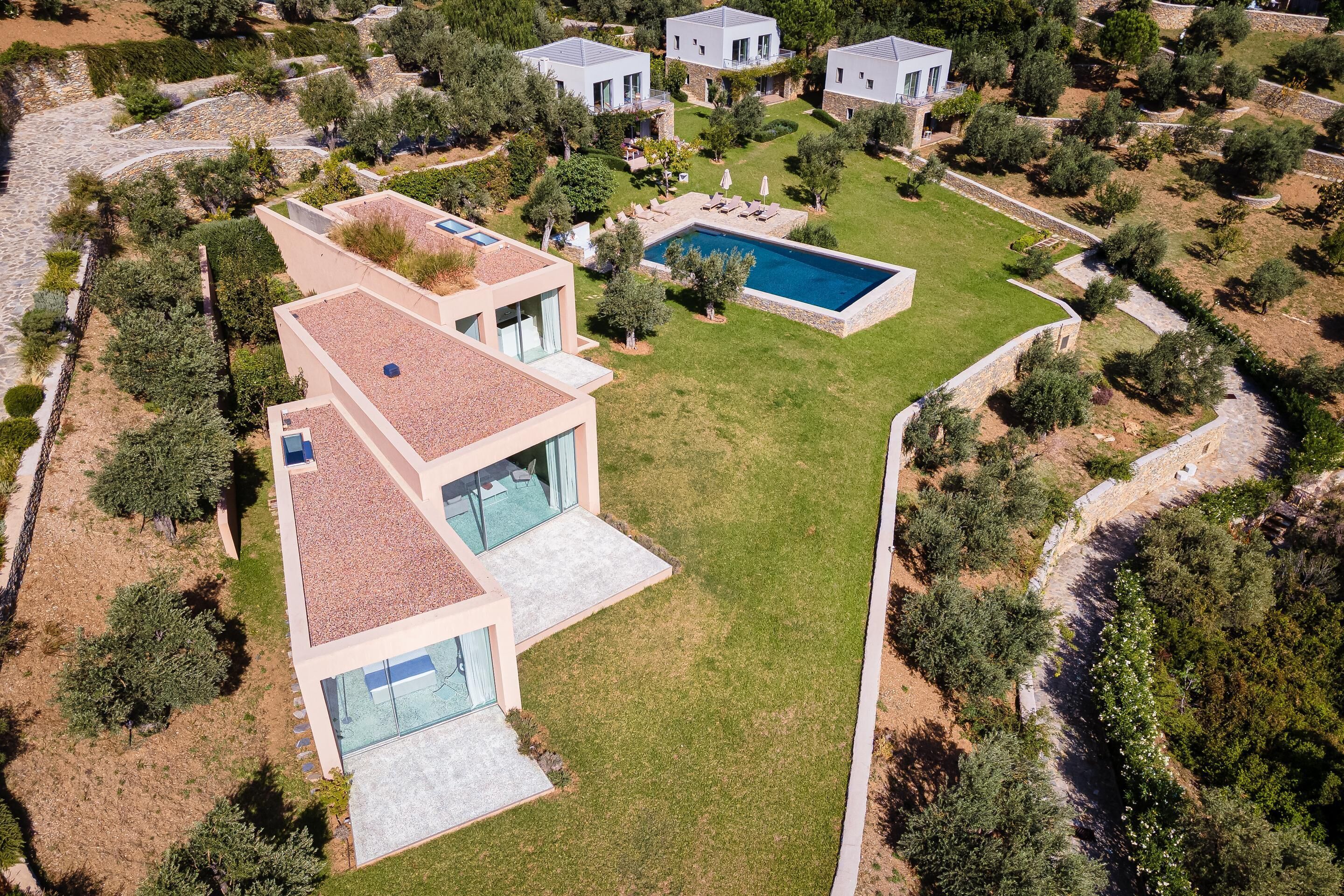 Une maison moderne dotée d’une piscine, entourée d’un jardin bien entretenu et d’arbres.