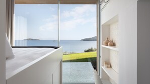 A modern bedroom with a large window overlooking a scenic coastal view. - Villa Pelagoon  (Skiathos)