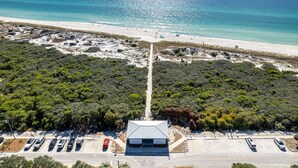 An aerial view of a coastal area with a parking lot, a building with a sloped roof, and a beach in the background. - Inlet Beach! Sleeps 10, 4 BR/3.5 BA , Pool & just minutes to the beach, Rosemary area and 30Avenue! (Inlet Beach)