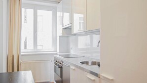Ett litet pentry med ett fönster, en diskho och en spis.