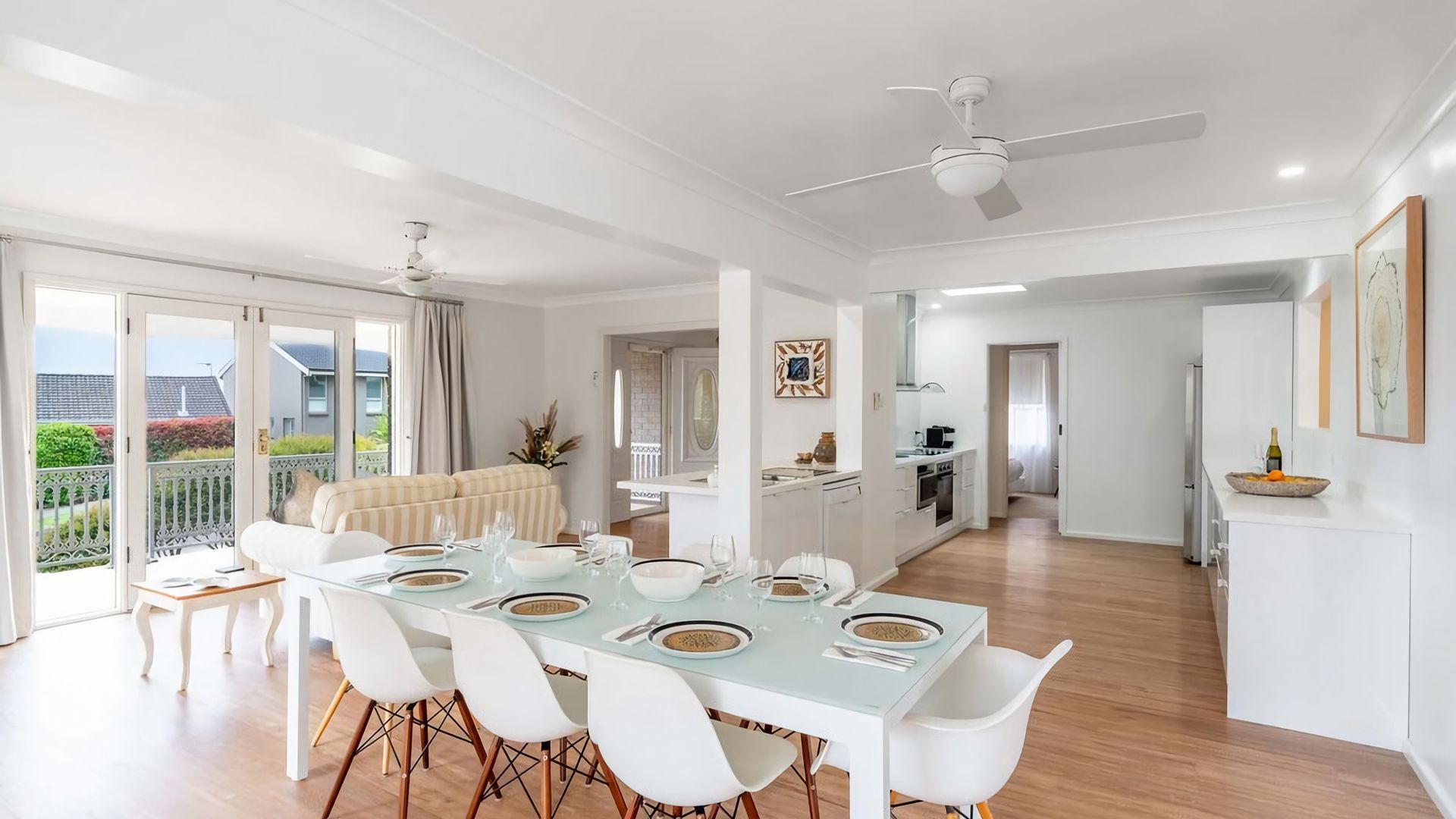 A modern apartment with a dining area, kitchen, and a balcony with a view.