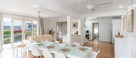 A modern apartment with a dining area, kitchen, and a balcony with a view.