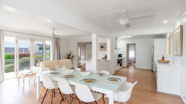 Un appartement moderne doté d’un coin repas, d’une cuisine et d’un balcon avec vue.