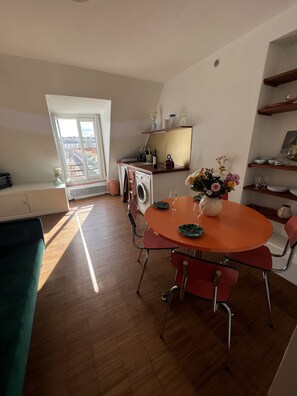 A modern apartment with a dining area, kitchen, and laundry room. - Sublime Appartement Parisien avec vue sur la Tour Eiffel (Paris)