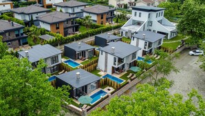 A residential area with modern houses, a swimming pool, and a well-maintained lawn. - Vital Home (Sapanca)