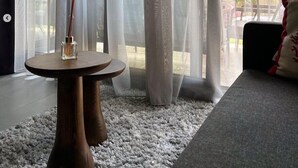 A room with a round wooden table, a white rug, sheer curtains, and a view of the outdoors. - Vital Home (Sapanca)