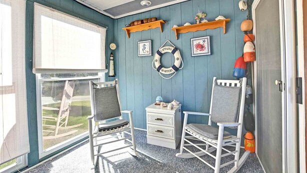 A room with two rocking chairs, a small white dresser, and nautical-themed decorations including a life ring and a lighthouse. - 2 Bed/2 Bath Condo in Bethany Meadows Community, located 3 miles from Bethany Beach! Dog Friendly, Community Pool, WIFI and more! (Frankford)