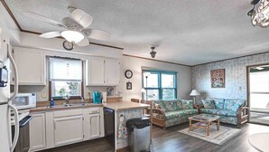 A compact living space with a kitchenette, a dining area, and a seating area with a patterned sofa. - 2 Bed/2 Bath Condo in Bethany Meadows Community, located 3 miles from Bethany Beach! Dog Friendly, Community Pool, WIFI and more! (Frankford)