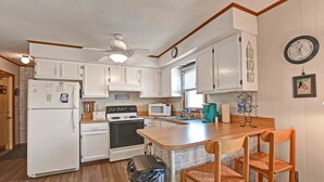 A compact kitchen with white cabinets, a microwave, a stove, and a trash bin. - 2 Bed/2 Bath Condo in Bethany Meadows Community, located 3 miles from Bethany Beach! Dog Friendly, Community Pool, WIFI and more! (Frankford)