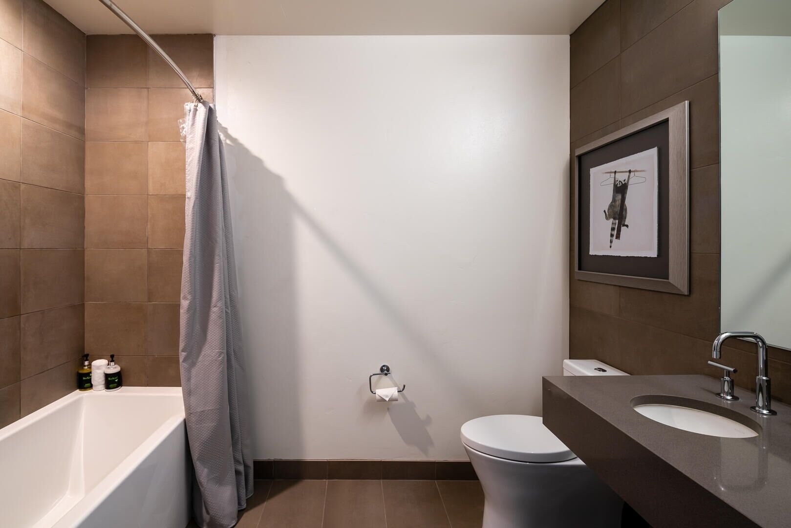 A modern bathroom with a bathtub, toilet, and sink.