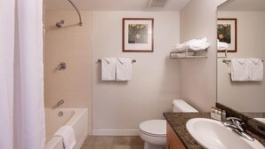 A bathroom with a bathtub, toilet, and sink. There are towels hanging on the wall and a framed picture above the toilet. - Premium Unit 4643- Fraser Crossing/founders Pointe Condo (Winter Park)