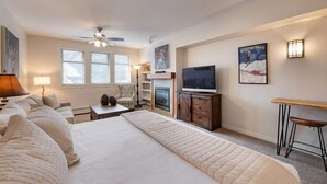 A hotel room with a large bed, a TV, a fireplace, and a desk with a chair. - Premium Unit 4643- Fraser Crossing/founders Pointe Condo (Winter Park)