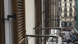 A narrow street with buildings on either side, a metal staircase, and parked cars. - PALAZZO SANT'ARCANGELO (Naples)