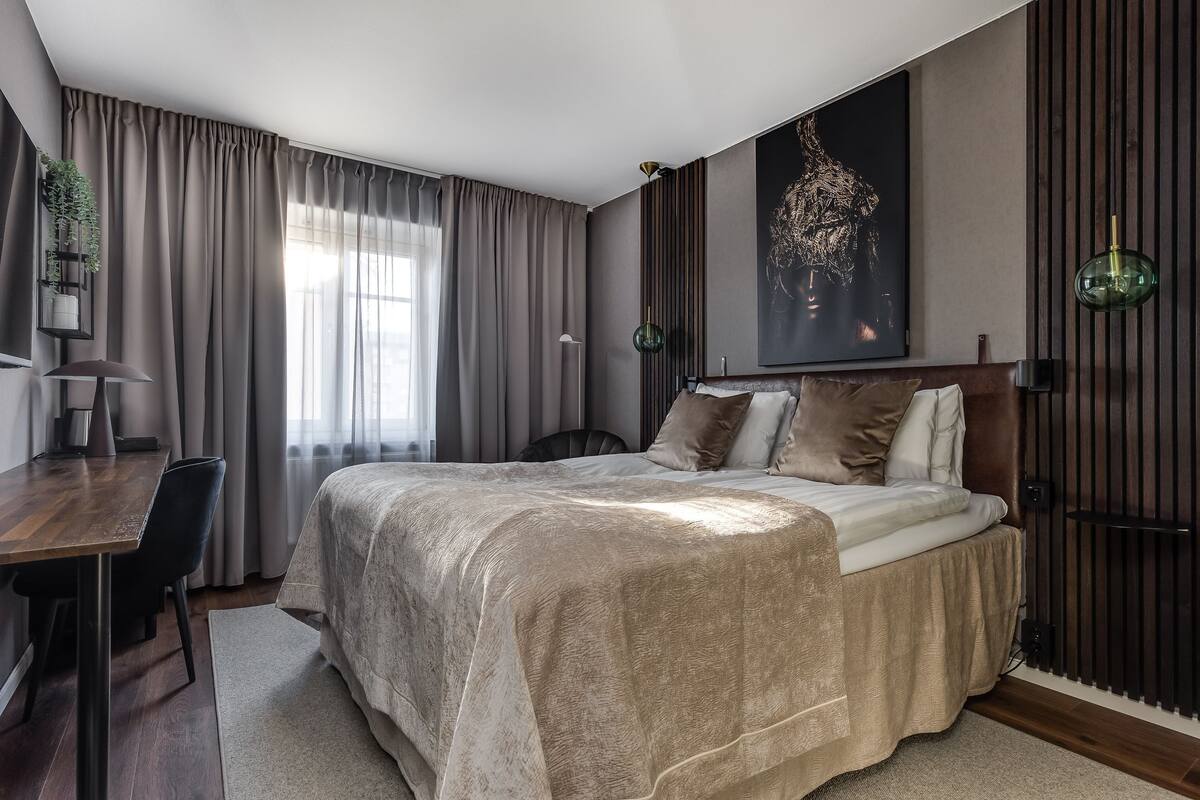 Une chambre à coucher moderne avec un grand lit, un bureau et une chaise.