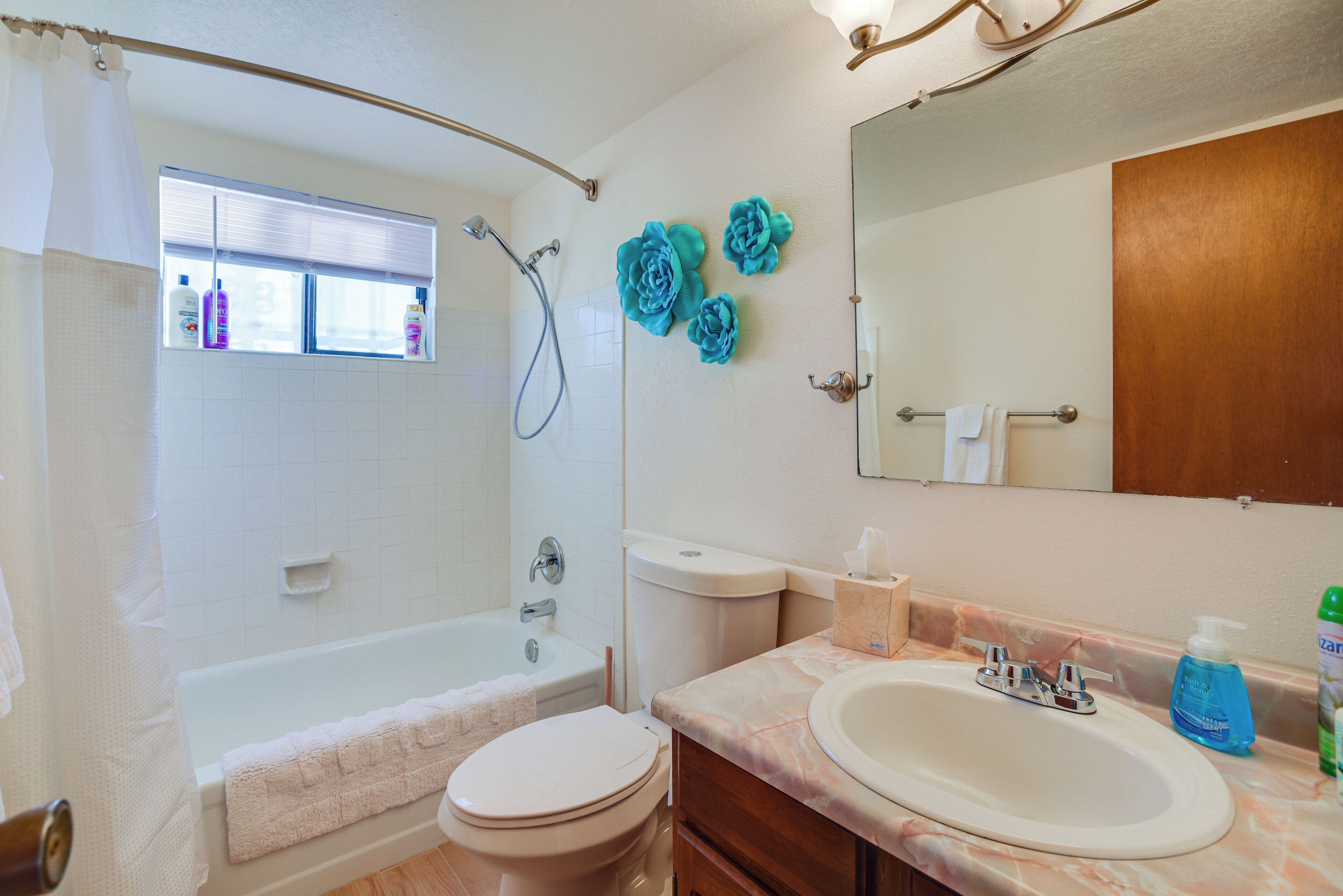 Une salle de bain avec une baignoire, des toilettes, un lavabo et un grand miroir.
