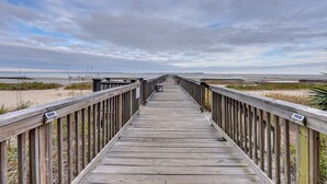 A wooden boardwalk leading to a beach with a cloudy sky. - Walk to Beach: Hilton Head Condo w/ Screened Porch (Hilton Head Island)