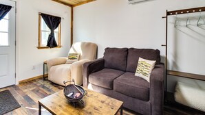 Ein gemütliches Wohnzimmer mit einer braunen Couch, einem beigefarbenen Sessel und einem Holztisch.